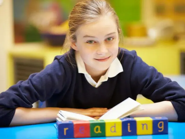 3rd grader student with book smiling