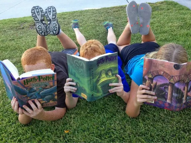 students reading book outdoor