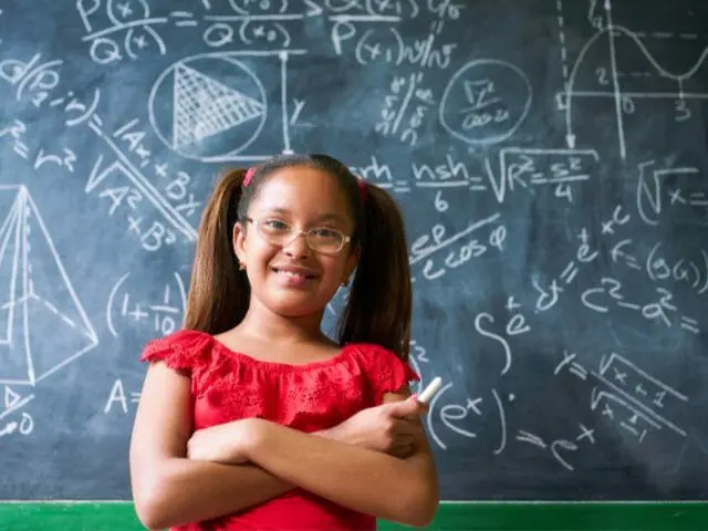 girl solving complex math problems on blackboard