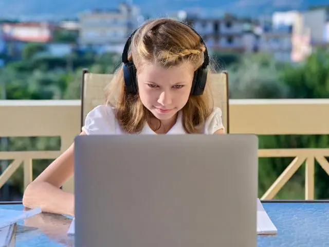 girl studying at home with headphone and laptop