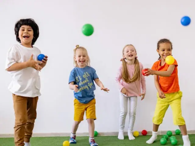 happy children playing balls in school