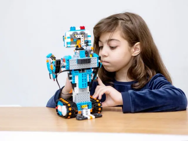 little girl constructing a lego robot