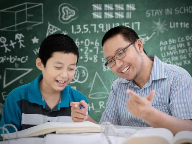 male with teacher in math class with book