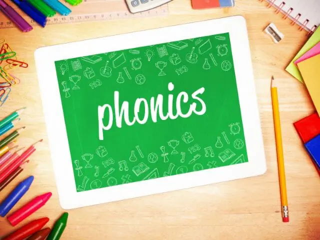 phonics word in tablet with writing tools on table