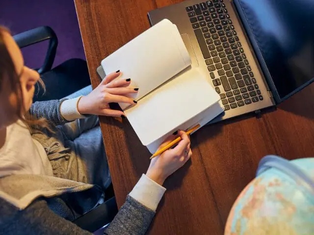 student with notebook and laptop picture