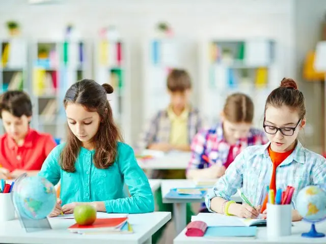 students writing essays in school class