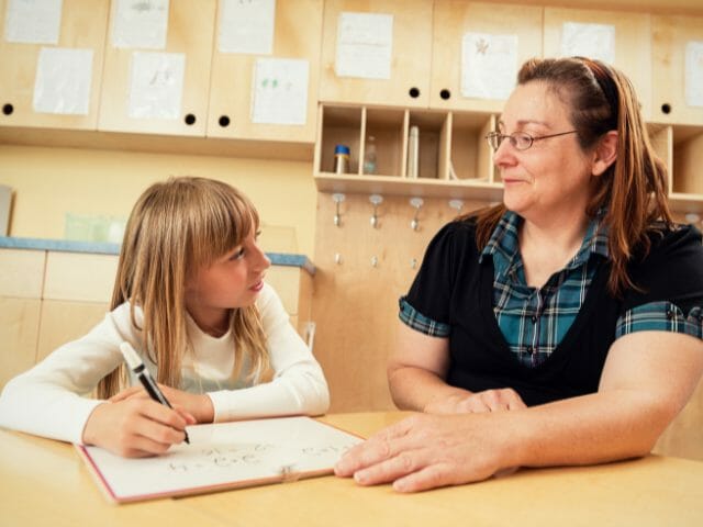 teacher talking with young student